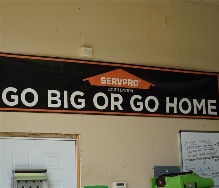 A SERVPRO banner in the garage that says "Go Big or Go Home."
